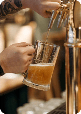 Beer being poured from a tap into a glass stein