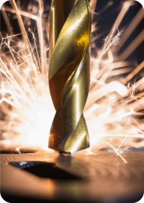 Drill bit hitting metal with sparks in the background
